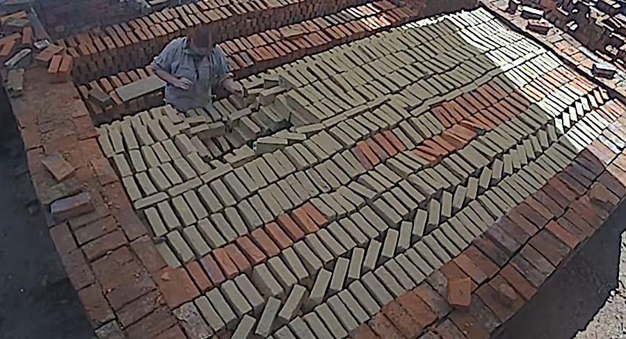 dried mud bricks are stacked to create a kiln, inside which the bricks will be heated to 2,000°F