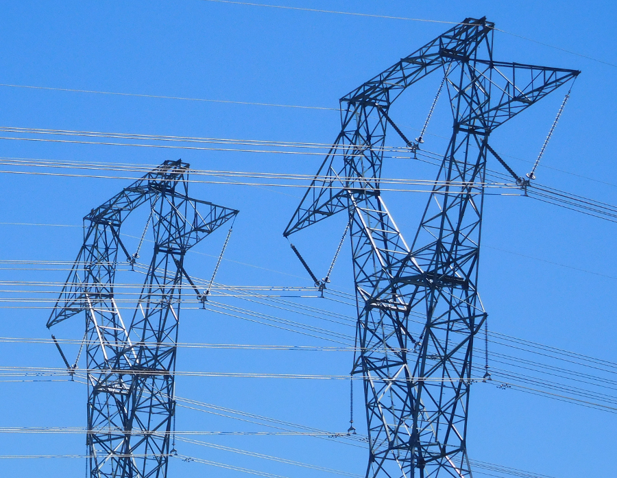 high voltage power lines transmit electricity via tall towers with wide rights-of-way