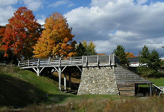 workers carried baskets of charcoal across a ramp to dump into the top of a burning iron furnance