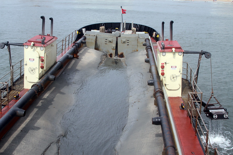 sand is pumped into hopper dredge ships for transport to replenishment sites