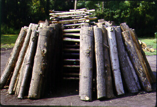 wood stacked for charcoal, with chimney in center