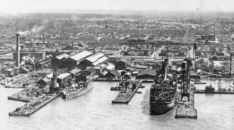 aerial view of the shipyard taken by a US Navy photographer in February 1923: a car float occupies Dry Dock 1, the battleship West Virginia (BB 48) is at Pier 3 (now Pier 6), and the SS Leviathan is at Pier 1 (now Pier 5)