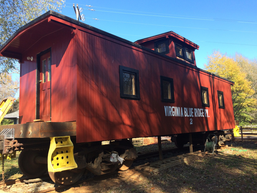 a caboose with the Virginia Blue Ridge Railway name is parked at the site of the Piney River depot